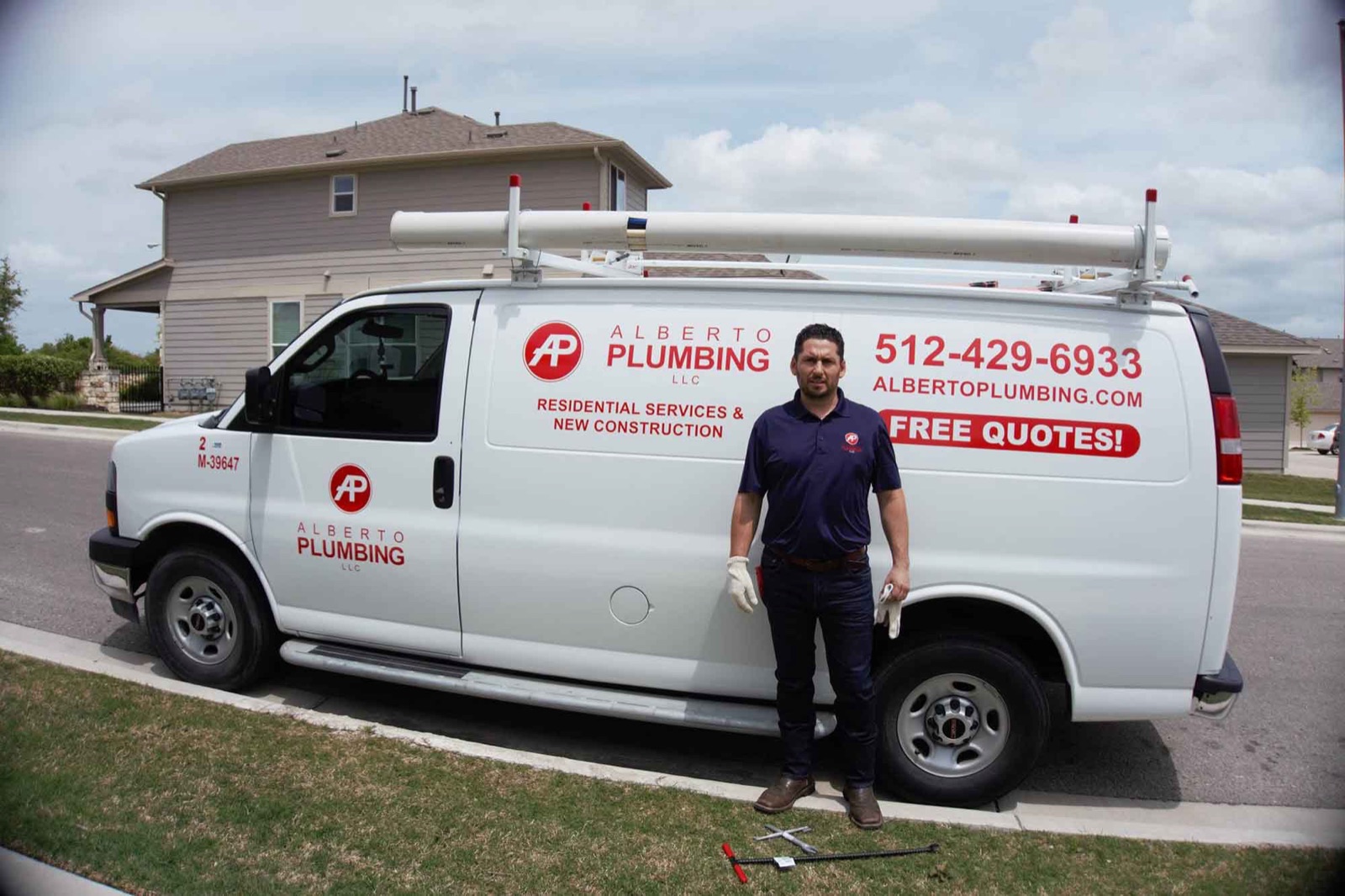 Jose A. Vital, owner of Alberto Plumbing, standing in front of his service van in Pflugerville, TX